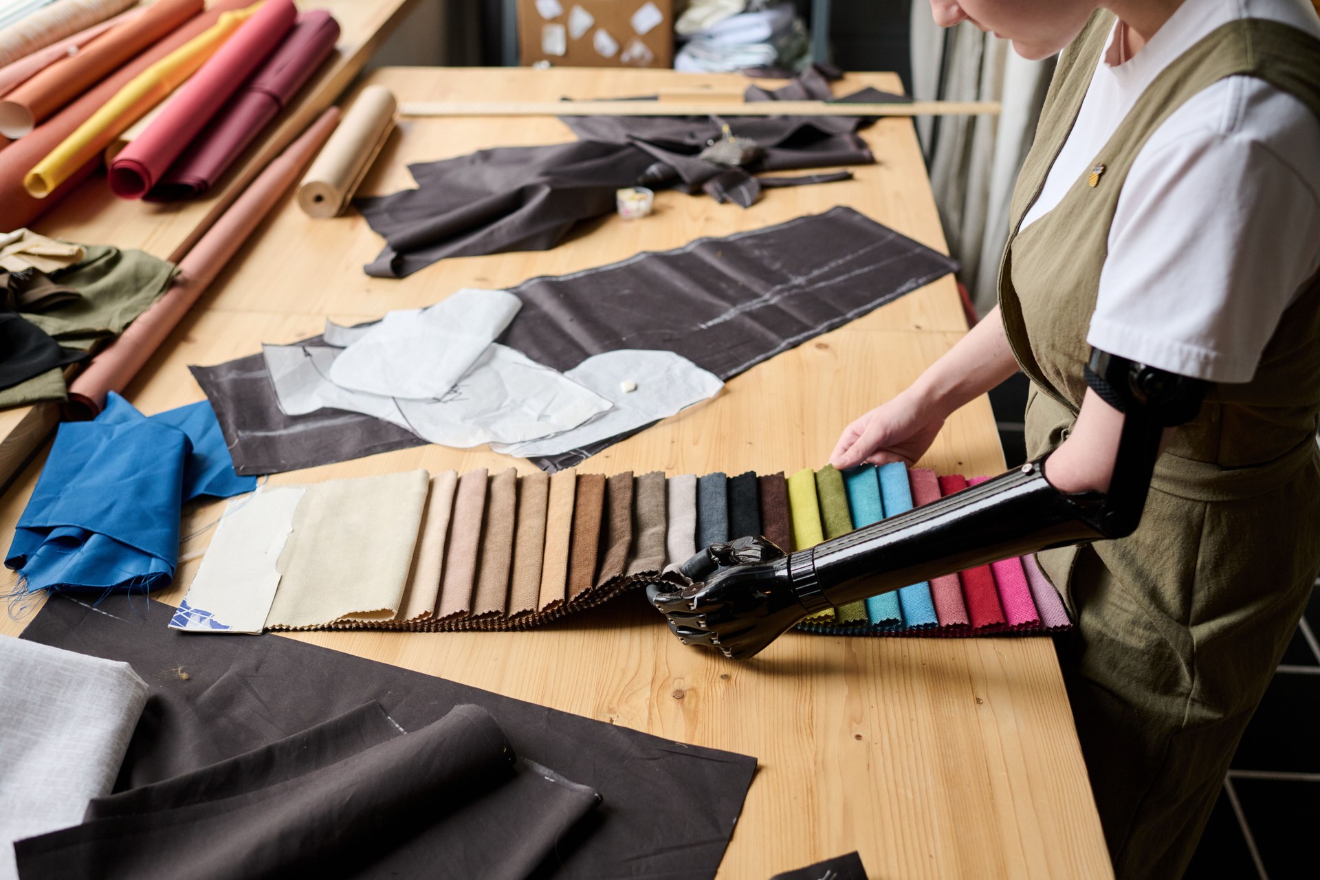 Partial arm of young woman with disability choosing color of textile